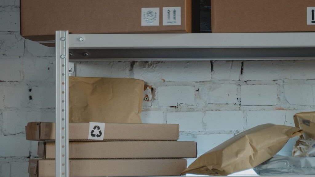 Stacked brown cardboard shipping boxes on steel warehouse shelves ready for order fulfillment