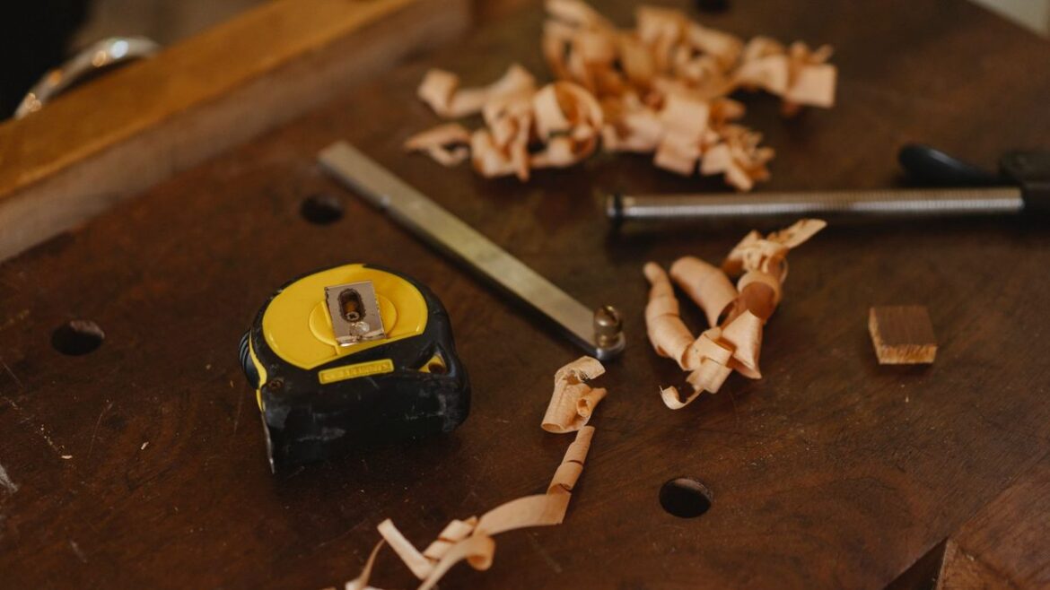 Woodworking tools, tape measure and wood shavings on a workbench suggesting custom-built craftsmanship