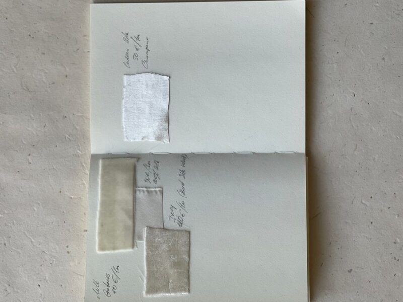 Top view of an open journal with handwritten notes recording entries on a neutral background