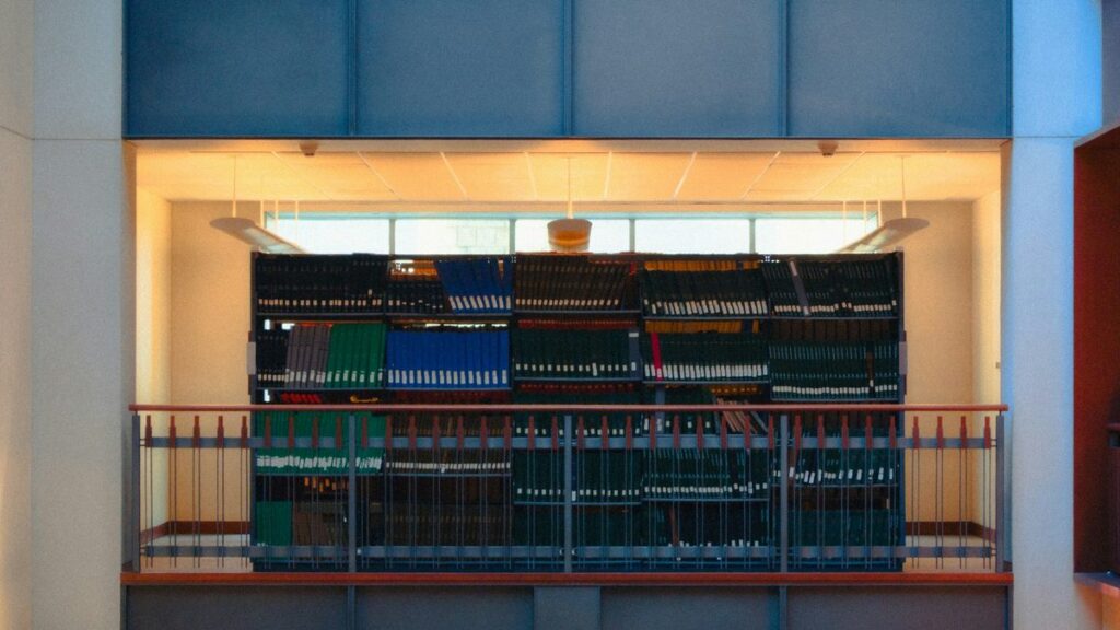 Library interior with long rows of bookshelves holding an organized knowledge collection